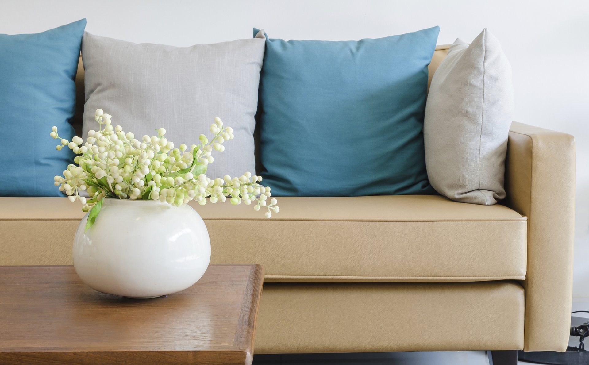 a living room filled with furniture and vase of flowers on a table