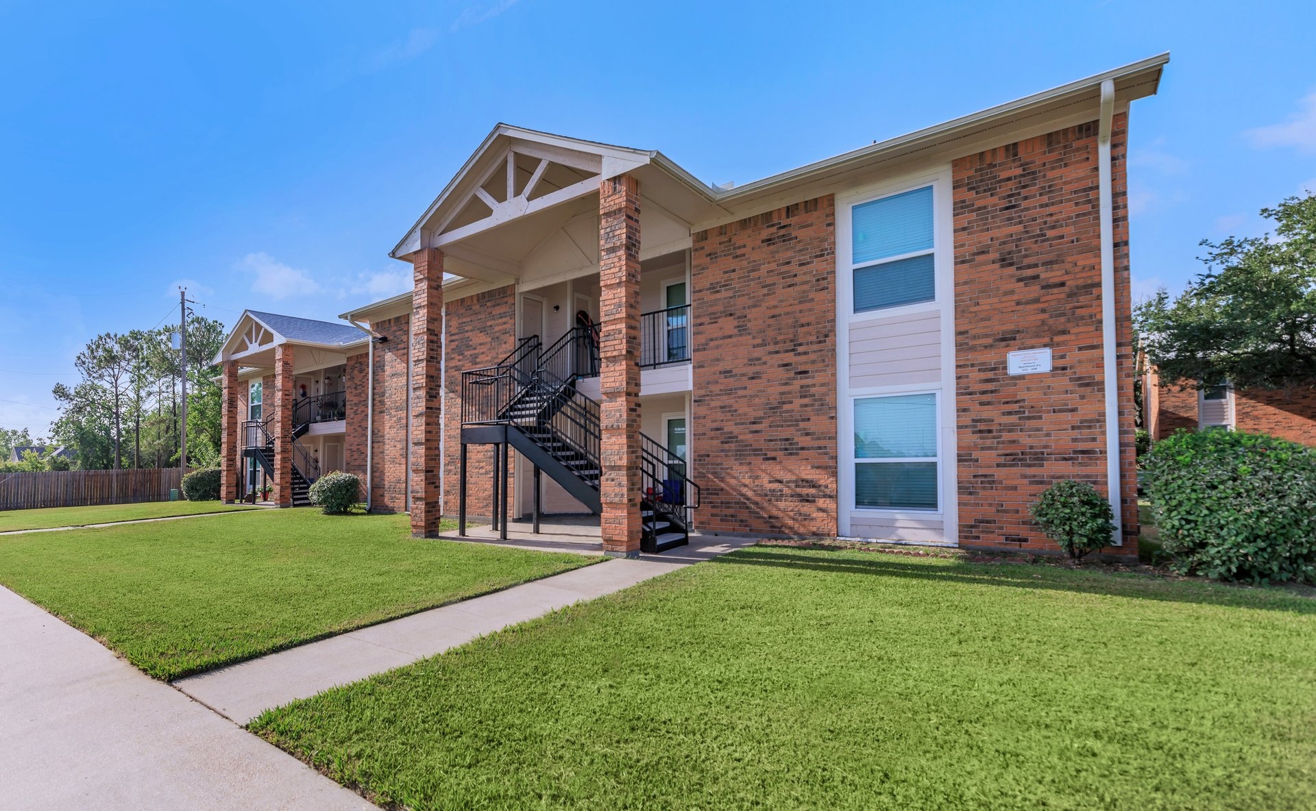 a large brick building with grass in front of a house